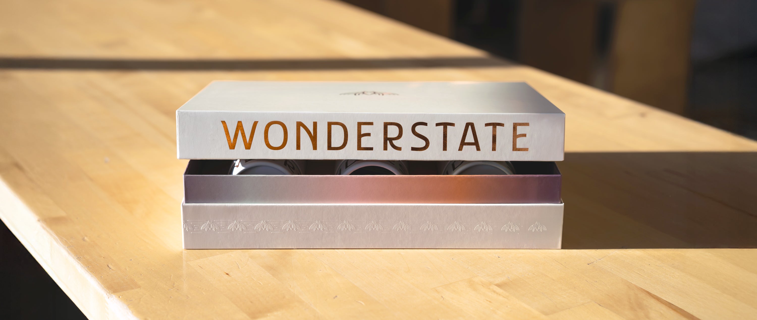 Metallic box with 'Wonderstate' branding on a wooden surface
