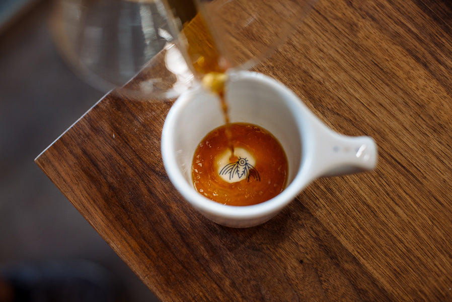 porcelain coffee mug with bee logo at the bottom