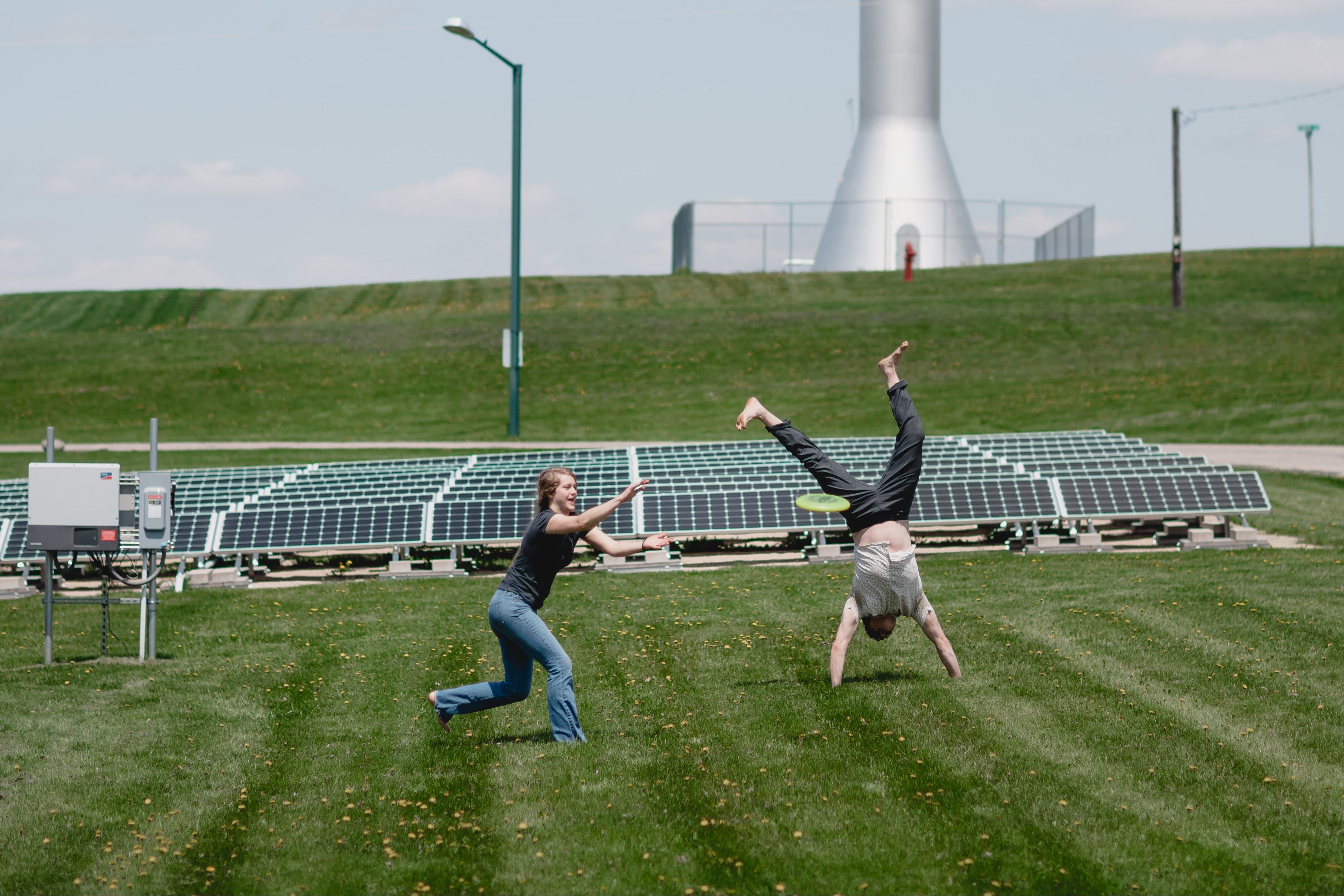 two people playing outside in front of solar panels