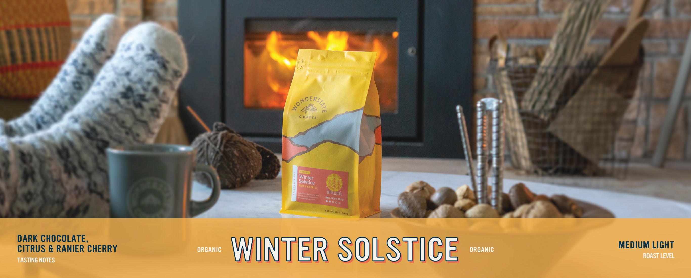 cozy fireplace scene with bag of winter solstice coffee
the text reads:
tasking notes: dark chocolate, citrus& ranier cherry
organic winter solstice
roast level: medium light