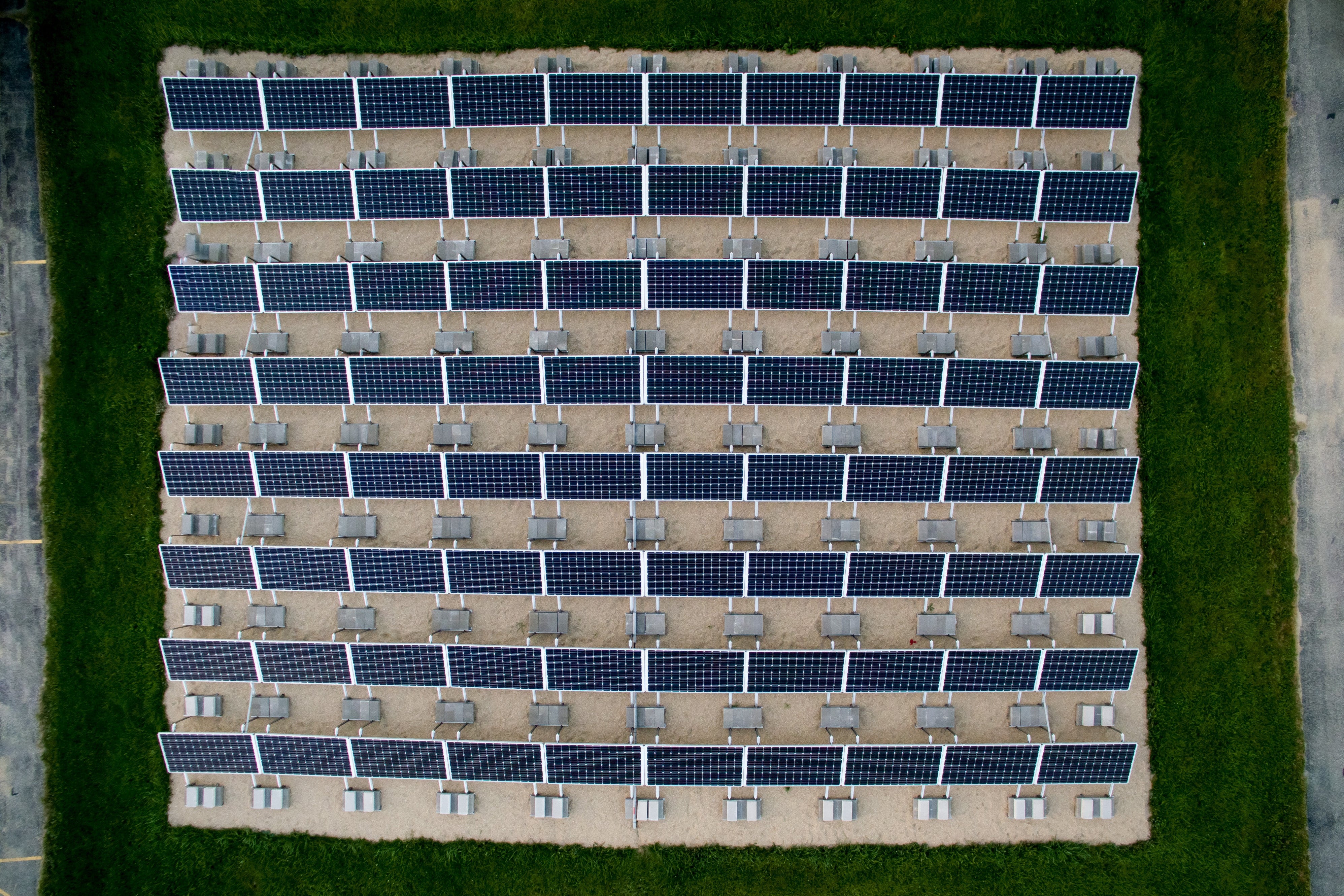 Grid of solar panels on a green grassy surface